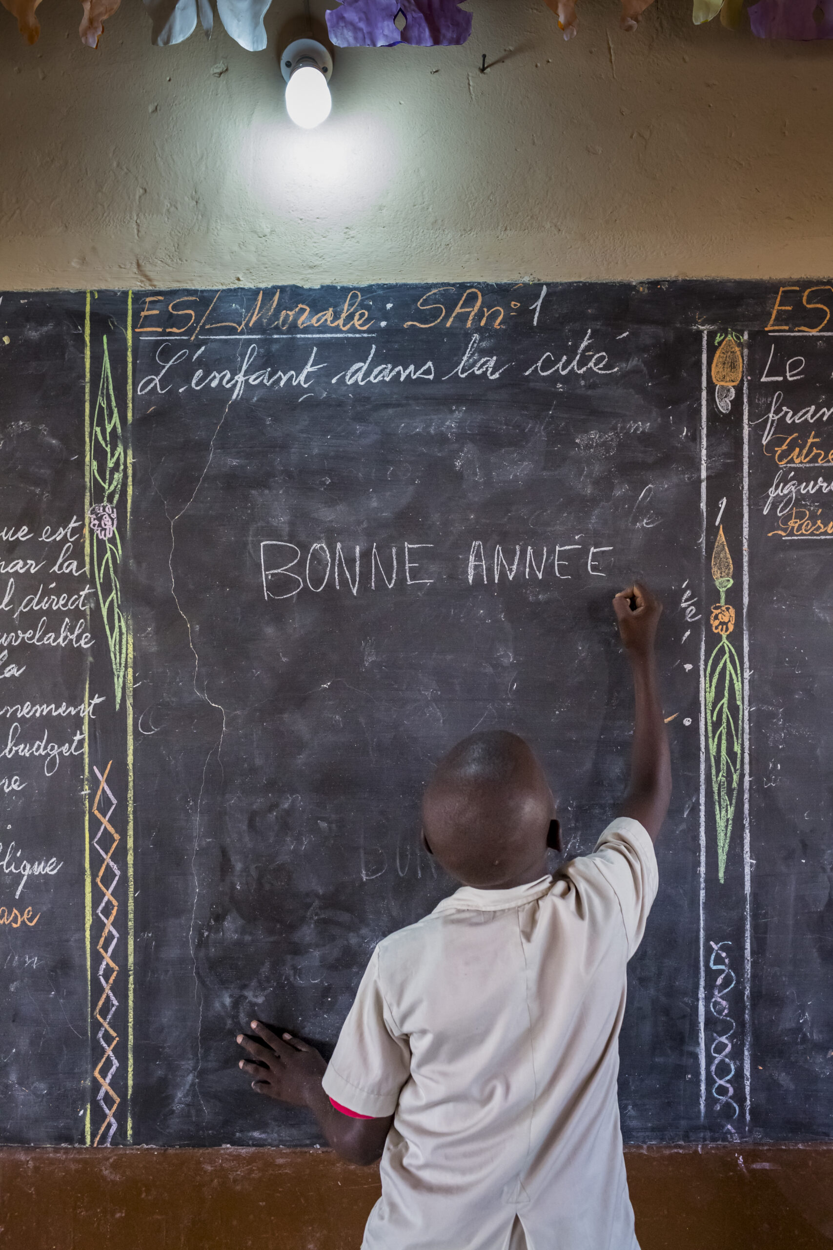 enfant pouvant étudier le soir grâce à l'électricité